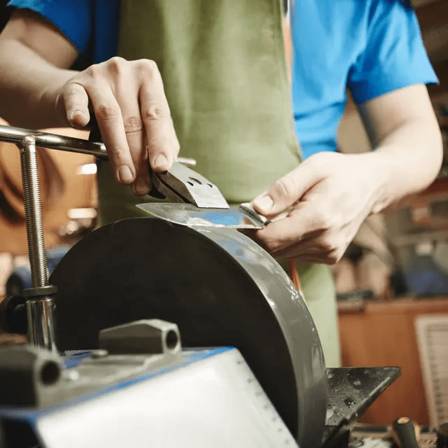 Blade being sharpened on a wet stone wheel